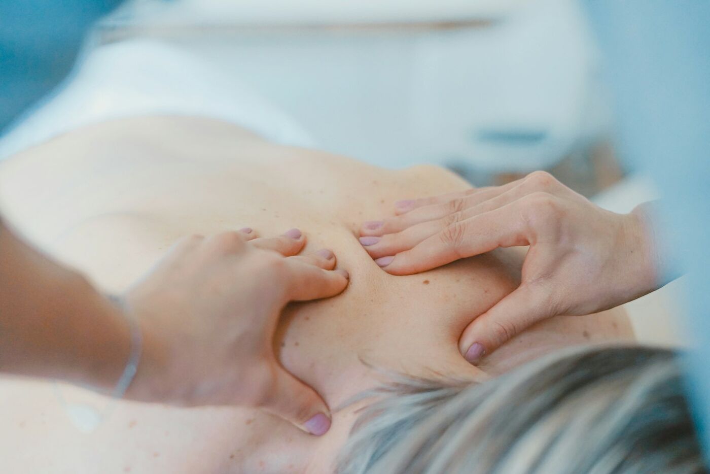 Hands working on the muscles of a patient's back