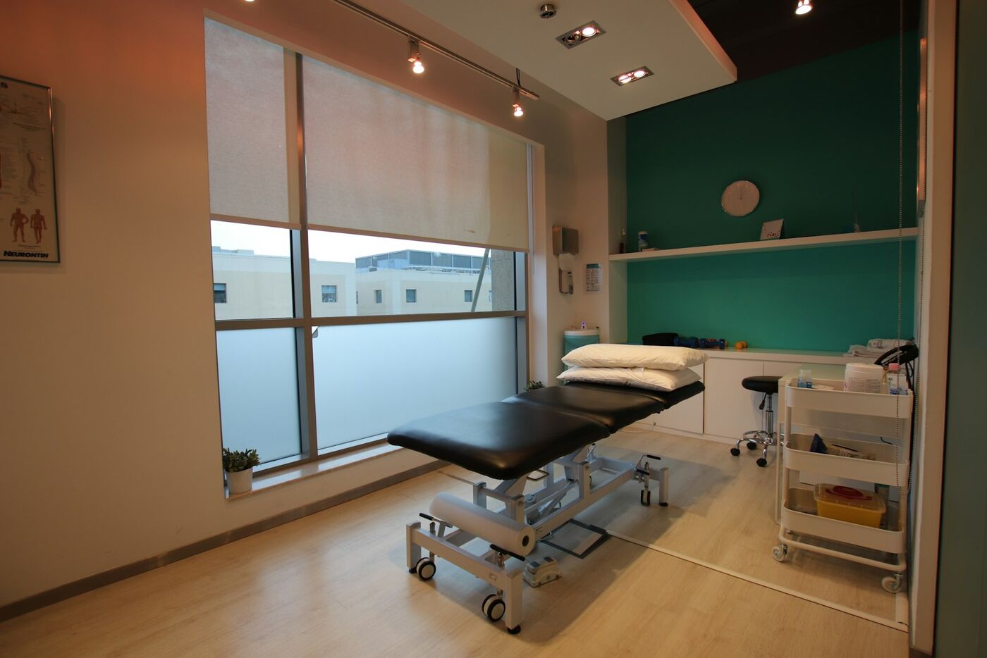 A calm treatment room with a bench by a large window