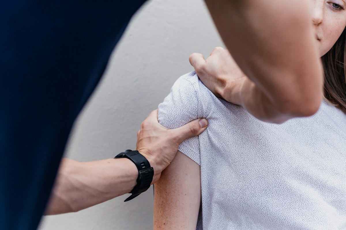 A physiotherapist testing how a patient's shoulder moves