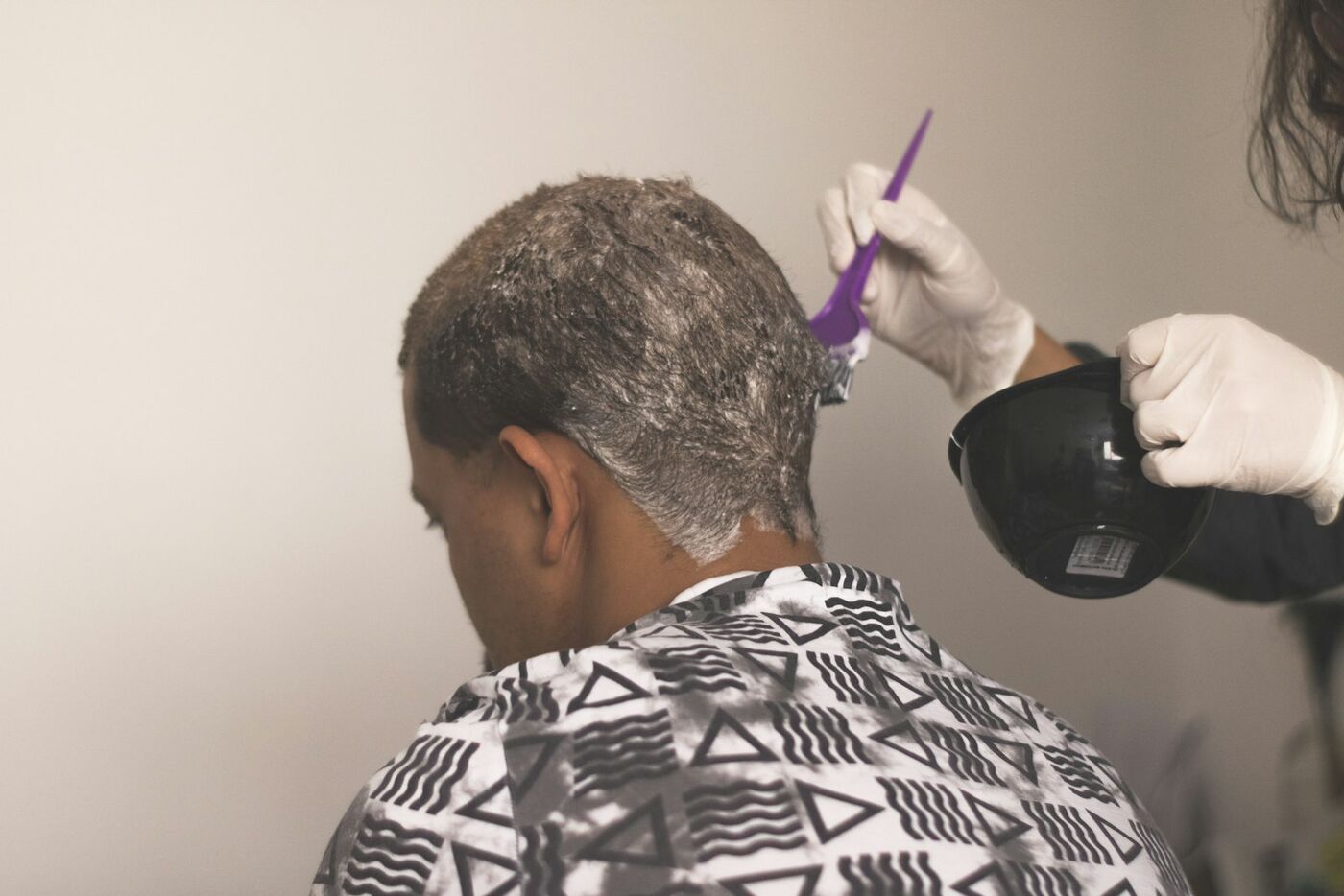 A stylist painting colour onto a client's hair