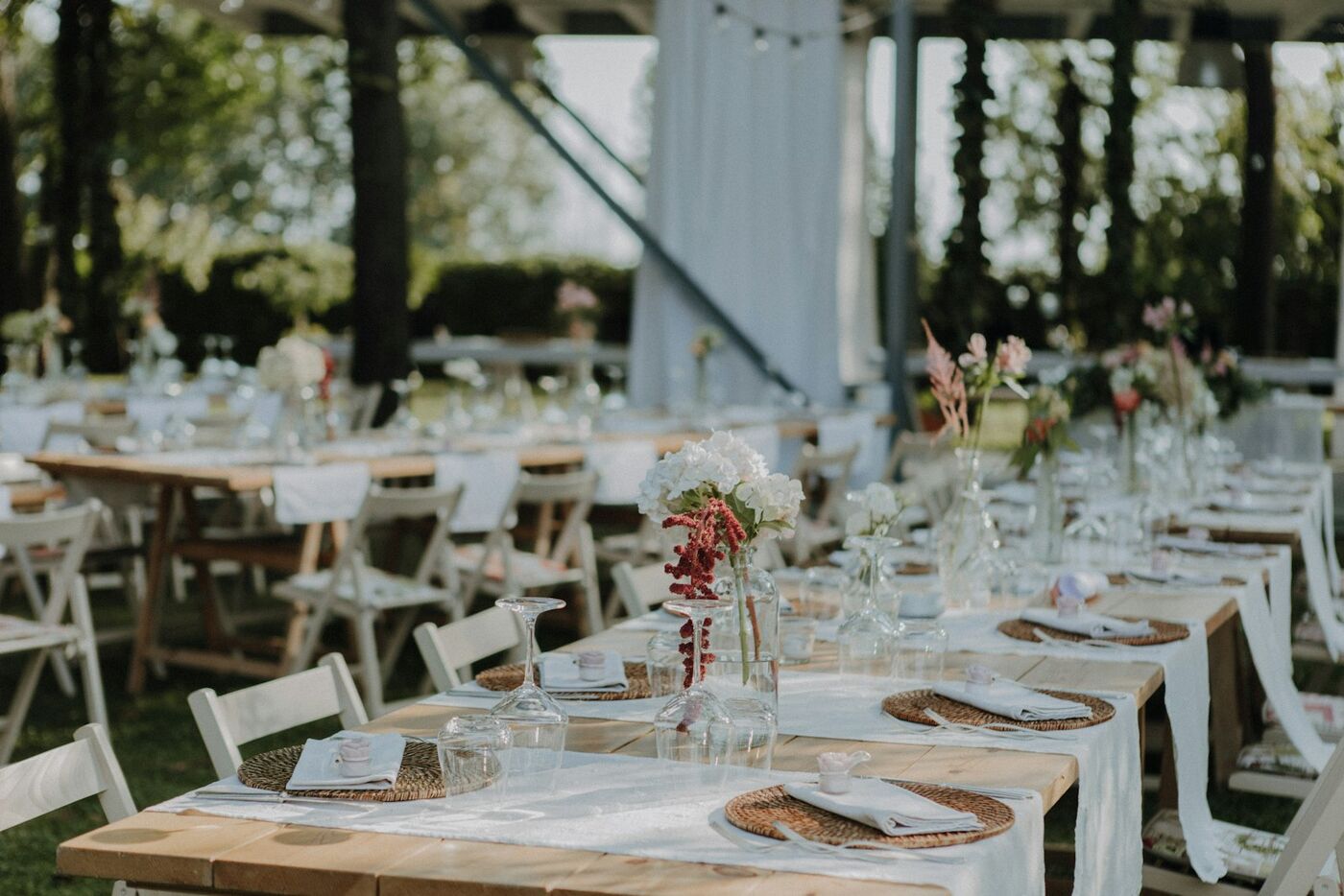 A long table set for a wedding dinner in a garden